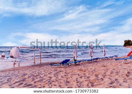 Sandy beach with sunbeds and big and beautiful blue sky