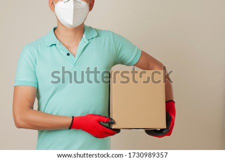 Delivery man holding cardboard boxes in medical rubber gloves and mask with copy space. Online shopping and Express delivery.