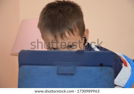 boy playing with digital tablet, watching cartoons or a movie or studying. with different emotions, surprised smiling online learning
