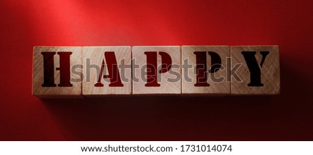 Wooden cubes with the word Happy on red background, Cheerful concept close-up.