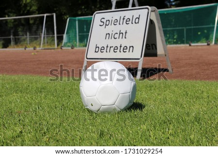 Symbol image for a cancelled or closed season in amateur football with a sign in german language saying „do not enter the sports field“ (Spielfeld nicht betreten)