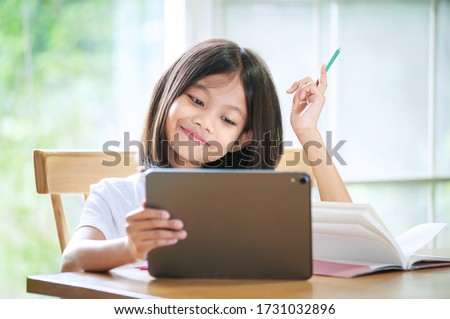 Asian little girl taking class on line and happy for Homeschool Quarantine coranavirus pandemic concept