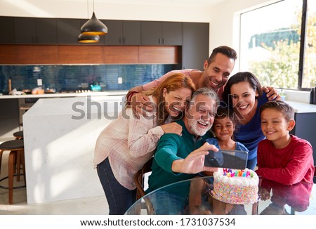 Multi-Generation Hispanic Family Taking Selfie To Celebrate Granddaughters Birthday At Home Royalty-Free Stock Photo #1731037534