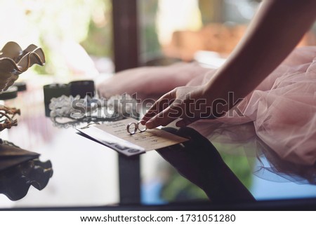 Woman's hand taking the rings before her wedding on the wedding invitation with Spanish text "we get married".