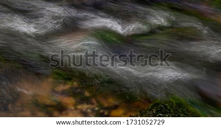 Abstract colorful picture of flowing water. Long shutter speed of a river. Paint with light. smooth small waves, copy space, place for text.