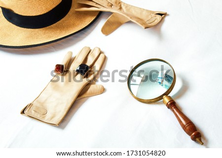 Image of female accessories of a female detective like magnifying glass rings and hat to investigate without being recognized