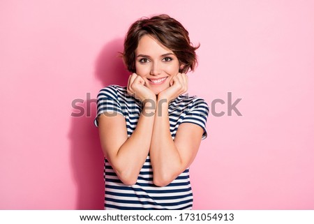 Photo of pretty nice sweet lady toothy smile holding arms on cheekbones overjoyed thankful wear casual white blue t-shirt isolated pastel pink color background