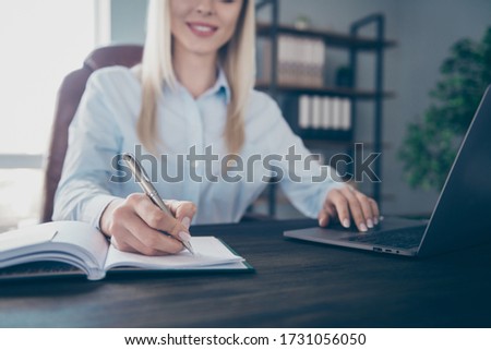 Croped photo of attractive confident business lady notebook table read corporate report insurance agent noting details personal planner wear shirt sitting modern interior office indoors