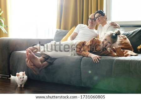 Happy family relaxing and watching TV show at home