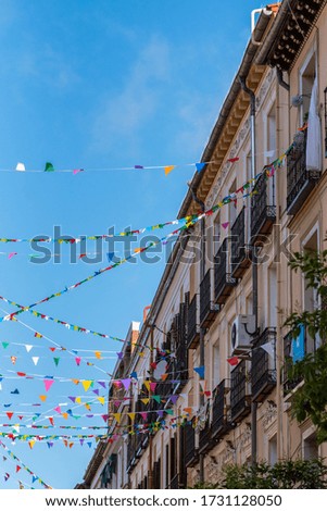 Street full of colored pennants crossing the street of the city center on a sunny day, Madrid, Spain.