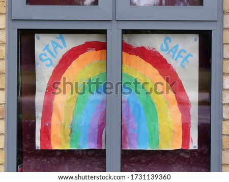 Colourful rainbow painting with message stay safe in window of primary school. A sign of gratitude to NHS and key workers during the Coronavirus (COVID-19) pandemic.