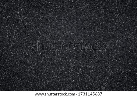 Asphalt texture, black pattern of roadway, grainy surface of pavement. Abstract dark wallpaper. Royalty-Free Stock Photo #1731145687