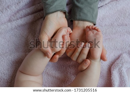 Baby feet in mother hands. Mom and her Child. Masseur massaging little baby's foot. Happy Family concept. Beautiful conceptual image of Maternity