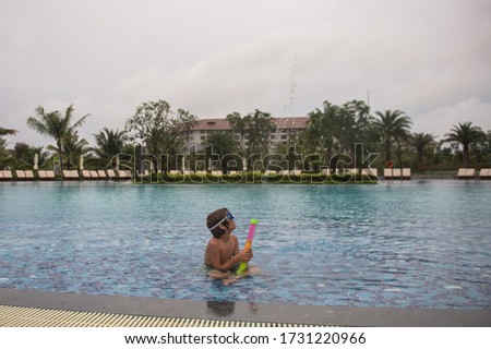 An empty pool at the hotel. A child swims playing alone