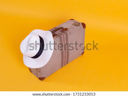 suitcase photo camera hat, yellow background, travel concept