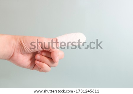 The index finger with the bandage in the accident pointed the finger away on clean background.