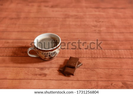 cup of coffee with chocolate on a wooden floor


