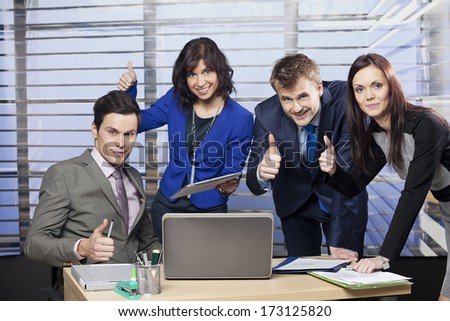 Successful business team giving thumbs up 