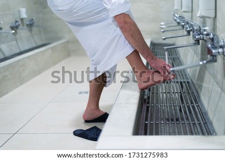 Muslim man taking ablution for prayer. Islamic Religious Rite Ceremony Of Ablution. Young Muslim man perform ablution (wudhu) before prayer. Royalty-Free Stock Photo #1731275983