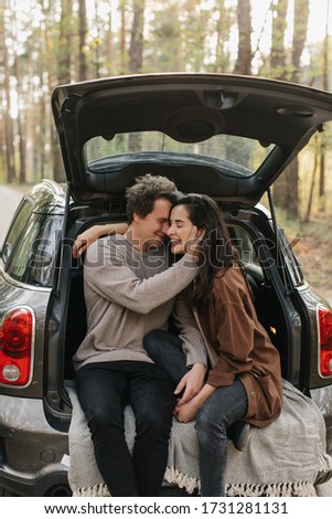 Young beautiful couple relaxing together sitting inside a car