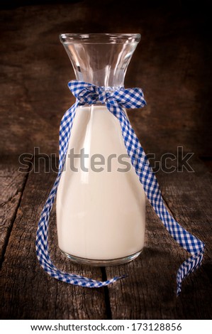 Old style bottle filled with cow milk on the wooden table