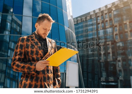 Caucasian young businessman reads the text on a tablet. The concept of a business man on the street.
