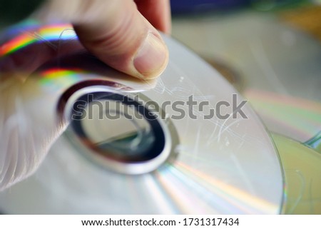 Damaged disc with scratches hold by a hand