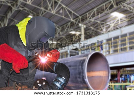 Craft man In A Safety Suit Is Welding A Metal Pipe