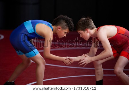 Young wrestlers shaking hands at the start of a match showing good sportsmanship