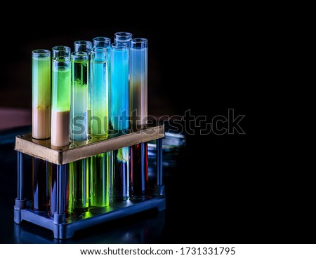 Cocktails in test tubes - creative alcohol bar drinks. Rainbow liqhuids in tubes. Copy space.