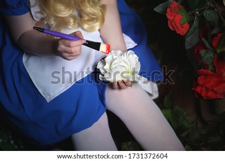 Girl in a blue dress on a background of white roses
