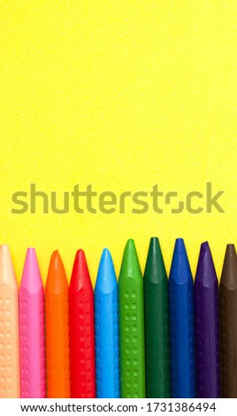 Crayons of different colors on a yellow background. Copy space. drawing concept