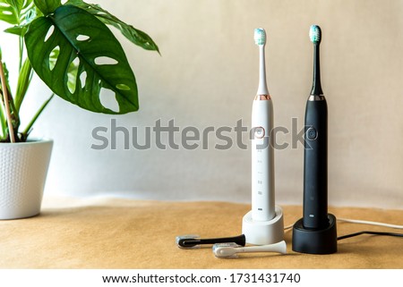 Modern rechargeable sonic or electric toothbrush set with charger in bathroom. Concept of professional oral care and healthy teeth by using ultrasonic smart toothbrush. Minimal design Royalty-Free Stock Photo #1731431740
