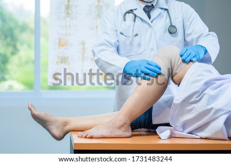 close-up hand wear medical gloves doctor examining head of patient with knee problems in clinic. Royalty-Free Stock Photo #1731483244