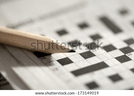 Close up view of a blank crossword puzzle grid with black and white squares and a pencil Royalty-Free Stock Photo #173149019