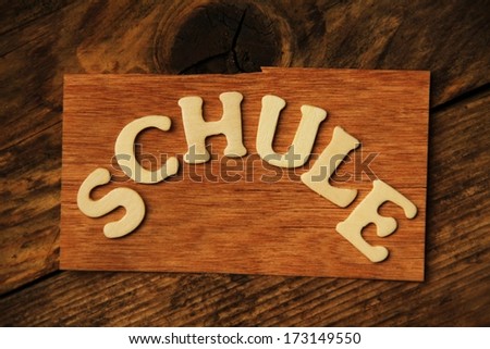 the German word SCHULE ( school ) on wood 