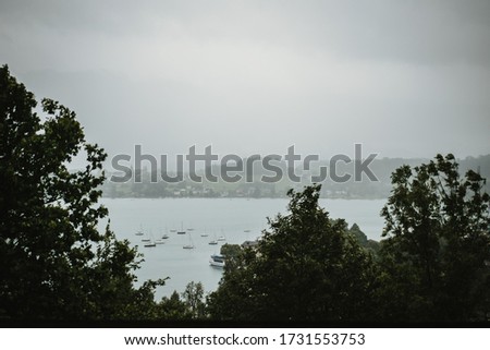 photo of a cloudy lake with boats
