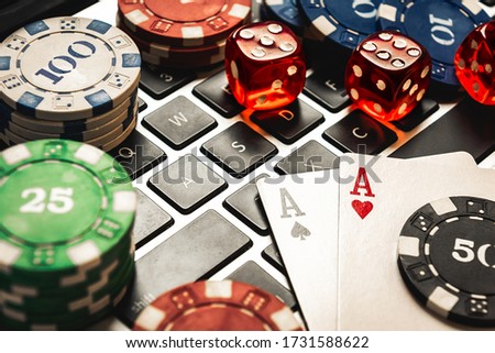 Online Poker Concept Image Including Dices, Betting Chips and Aces Cards Over a Laptop Keyboard Royalty-Free Stock Photo #1731588622