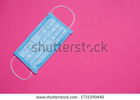Blue medical surgical mask for protection against the virus on a colored background
