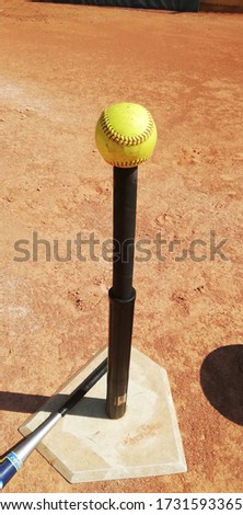 softball ball on t ball and bat in infield