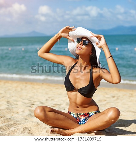 Woman in hat and sunglasses relaxing on a  summer  beach