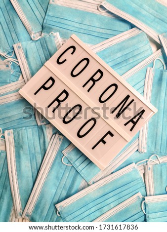 Blue surgical face masks with a white light box stating Corona Proof
