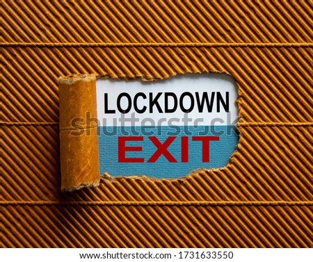 The text 'lockdown exit' appearing behind torn brown paper. Business concept. Royalty-Free Stock Photo #1731633550