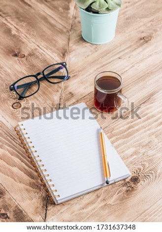 Office workplace with Blank open notebook and cup of coffee on rustic wooden background. Workplace for the creative work of designer at home. Selective focus, Business-finance or education concept.