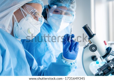 coronavirus covid-19 vaccine in hands of pharmacuetical bio research scientist in vaccine development laboratory, coronavirus covid-19 vaccine development program, selective focused Royalty-Free Stock Photo #1731649345