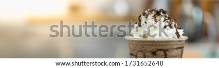Closeup of takeaway plastic cup of coffee mocca frappe with whipped cream and chocolate sauce and chips with copy space. Using for cover page. Royalty-Free Stock Photo #1731652648