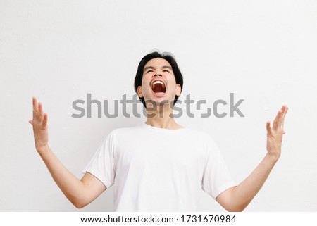 Attractive happy asian male in white shirt in studio portrait with white background.