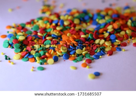 colorful round sprinkles or sugar confetti on white background 