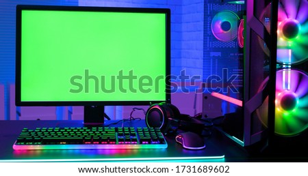 Green screen monitor with powerful personal computer for e cyber sport gamer on the table at home
