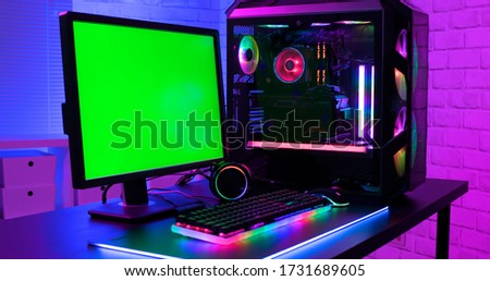 Green screen monitor with powerful personal computer for e cyber sport gamer on the table at home